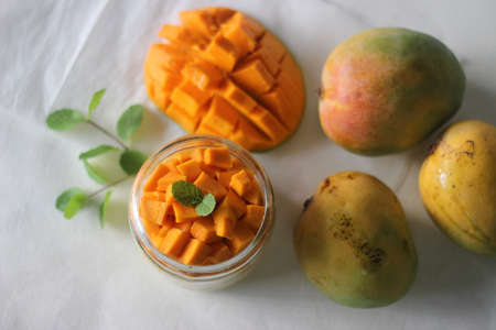 Vanilla custard topped with fresh cut mangoes served in a jar. Shot on white background.の写真素材