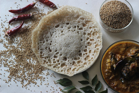 kodo millet hoppers prepared with a batter of kodo millet, flattened rice and coconut fermented with...