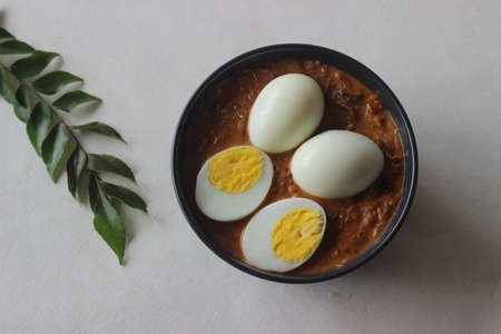 Kerala style spicy egg curry. Boiled egg in a spicy gravy of onions, tomatoes and spices. Locally known as egg roast. Shot on white background.の写真素材
