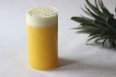 Chilled pineapple juice to beat the summer heat. Home made juice served in long glass decorated with a pineapple wedge. Shot on white backgroundの写真素材