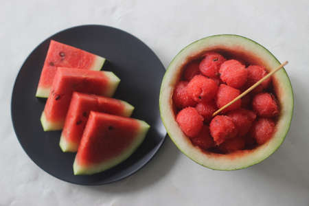 Fresh watermelon slices. Its good to keep your body cool from the summer heat. Shot along with water melon scoops and juice on white background.の写真素材