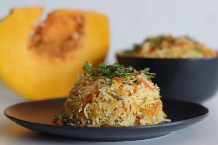 One pot rice preparation with basmati rice, grated pumpkin and carrots. Commonly called as carrot pumpkin pulao. Shot on white background.の写真素材