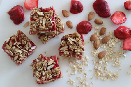 Strawberry oats almonds Breakfast bar. No flour breakfast bar with rolled oats, almonds, cream cheese and fresh strawberries. Shot on white background along with fresh strawberries.の写真素材