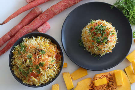 One pot rice preparation with basmati rice, grated pumpkin and carrots. Commonly called as carrot pumpkin pulao. Shot on white background.の写真素材