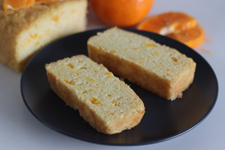 Orange cake. Tea time cake with orange juice and orange pulp. Shot along with fresh oranges on white...