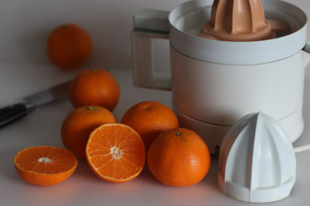 Sliced Malta or Valencia Orange. It is a citrus fruit grown in India, commonly called as sangtra shot along with citrus juicer on a white background. It is a large orange with smooth pebbled surfaceの写真素材