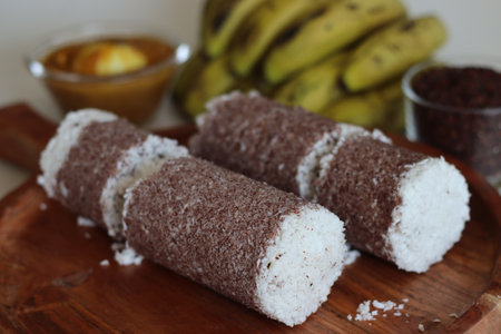 Poongar rice puttu served with spicy egg curry and bananas. Steamed rice cake with poongar rice flour and layers of grated coconut. Prepared in traditional long cylindrical utensil called puttu kuttiの写真素材
