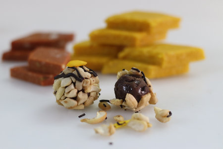 Kaju Choco Chips Laddu in front of Badam burfi and kesar barfi. Variety of indian sweets in one frame. Commonly distributed to celebrate festivals and special occasionsの写真素材