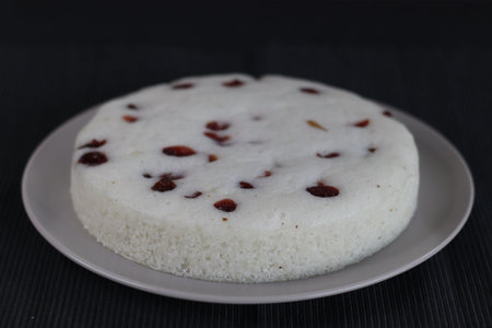 Vattayappam. Steamed spongy rice cake topped with dried cranberries. A traditional tea time snack from Kerala, prepared with a fermented batter of rice and coconut and often steamed in a round dish.の写真素材