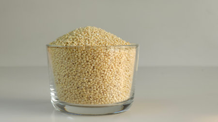 Proso millet, tiny round seeds with a golden hue kept in a glass bowl filled to the brim. Nutritious gluten free and versatile staple, suitable for healthy and vibrant food conceptの写真素材