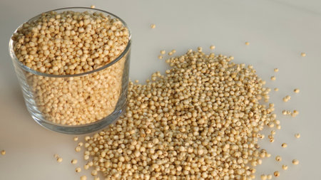 Closeup of sorghum millet grains kept in a glass bowl filled to the brim, highlighting the tiny, golden grains with a rich earthy hue. Perfect for food and health related conceptsの写真素材