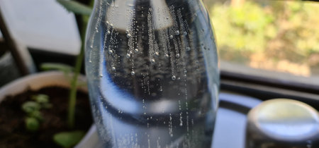 Effervescent bubbles dance in a glass bottle filled with crisp drinking water, creating a refreshing and invigorating sceneの写真素材