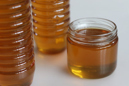 Golden homemade honey, meticulously crafted and beautifully packed in PET and glass bottles. Pure sweetness captured, perfect for natural, healthy living and wellness conceptsの写真素材