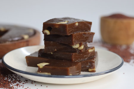 Slices of Ragi Halwa served in a round wooden tray, Indian dessert, nutritious, vegan, gluten-free,...