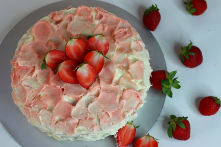 Buttermilk strawberry cake with rose pink icing and flower petal effect, topped with fresh strawberry slices. Ideal for dessert lovers, special occasions, and celebrations. Visually stunning photoの写真素材