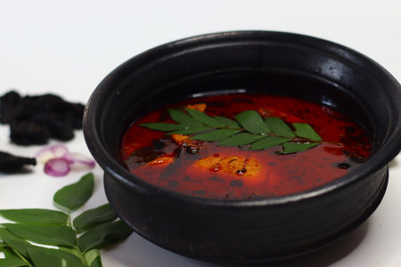 Tilapia fish curry served in a traditional black earthen pot, known as meen chatti in Malayalam, infused with South Indian spices, curry leaves, shallots, and black tamarind. Authentic and flavourfulの写真素材