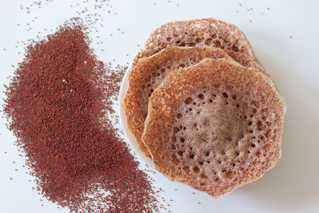 Ragi appams with crisp edges and soft center served on a ceramic plate, made from fermented finger...