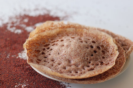 Ragi appams with crisp edges and soft center served on a ceramic plate, made from fermented finger...