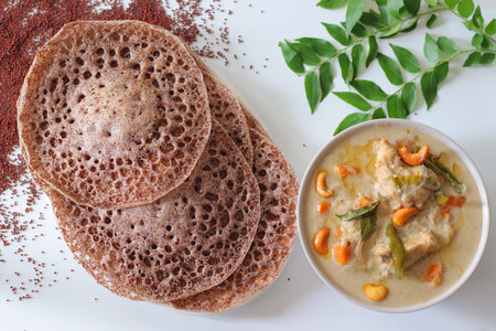 Ragi appams made from finger millet flour served with creamy vegetable stew, garnished with cashews...