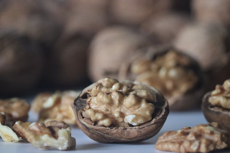 Walnuts in shell and shelled halves presented in a rustic close up, featuring rich brown textures...