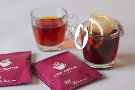 Tokyo, Japan, February 21, 2026: Single serve drip coffee bag placed over a glass cup with brand Hotel Metropolitan packaging. Convenient hanging paper filter brewing method commonly used in Japanのeditorial素材