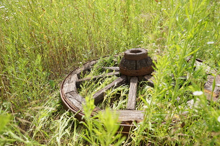 wooden wheel is on a green grassの写真素材
