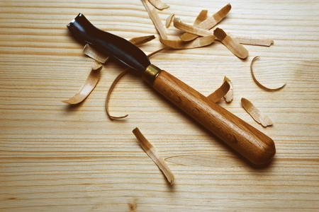 Tool for woodcarving on the table with chipsの写真素材