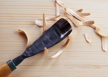 Tool for woodcarving on the table with chipsの写真素材