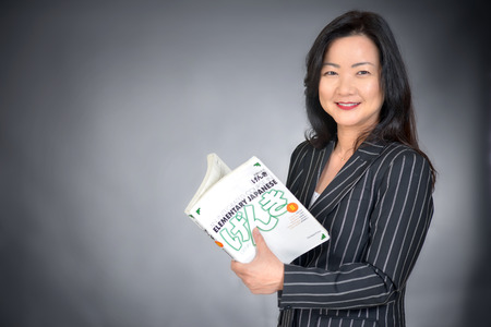 asian teacher holding a bookの写真素材