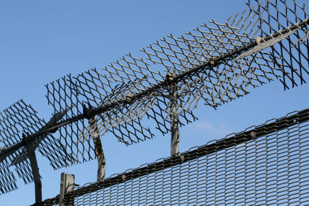Defences on top of metal fence against trespassers to gas storage facilities, Chelmsford, Essex,...