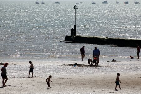 Silhouetted people enjoying the beach, Clacton, Essexのeditorial素材