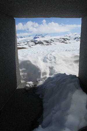 View through stone sculpture by Knut Wold in Jotunheimen National Park, next to Sognefjellet Tourist...