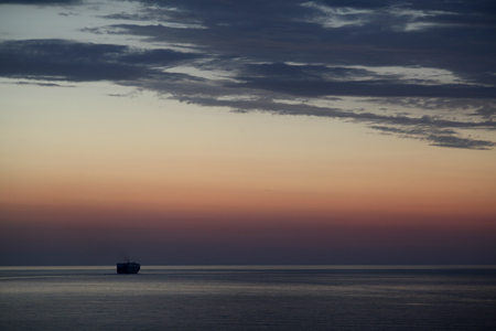 Cargo ship heading towards dusk, away from Stromboli, Italyの写真素材