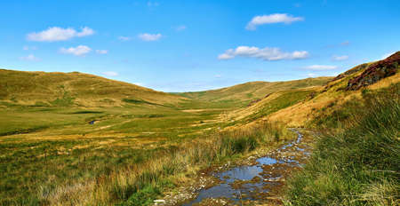 Scenic view of Cwm Hyddgen from the track to the east of the Afon (River) Hyddgen. The peak of Carn Hyddgen can be seen in the distance. Scene of battle by Owain Glyndwr against English rule 1401.の写真素材