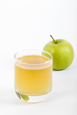 lass of apple juice and green apples isolated on whiteの写真素材