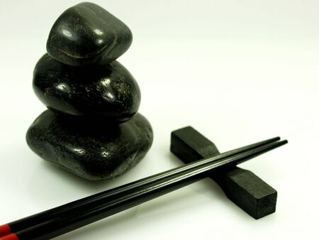 hot stones and black chopstick on a pure white backgroundの写真素材