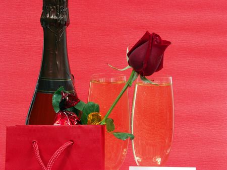 champagne bottle and two cups for celebrate san valentine`s day with a red bag and chocolatの写真素材