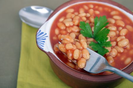 tasty tomato sauce beans on brown bowl with spoonの写真素材