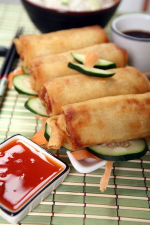 Crispy Chinese egg rolls with sweet and tangy chili sauce for dipping.の写真素材