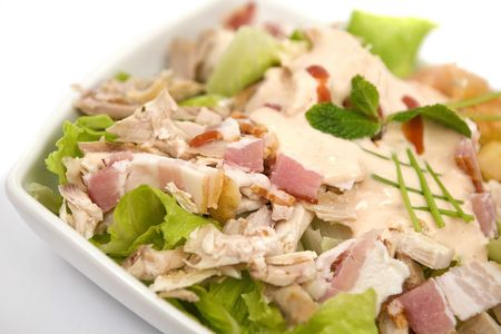 Chicken salad with bacon and sauces on white bowlの写真素材