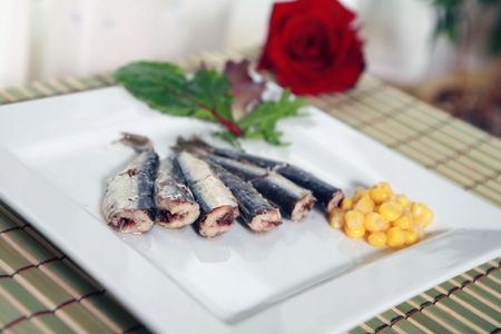 sardines in olive oil on white platter and lettuceの写真素材