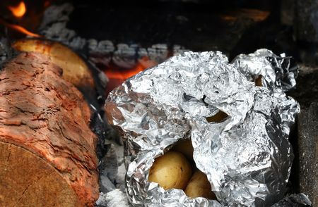 roasting potatoes on outdoor barbecue grillの写真素材
