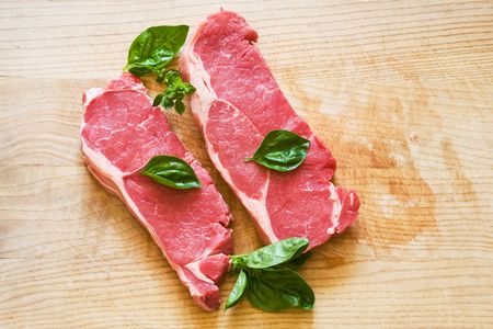 fresh and raw beef steak with green herbsの写真素材