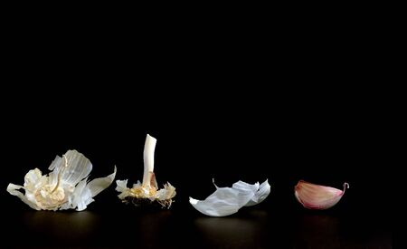 some garlic bulb and cloves on black backgroundの写真素材