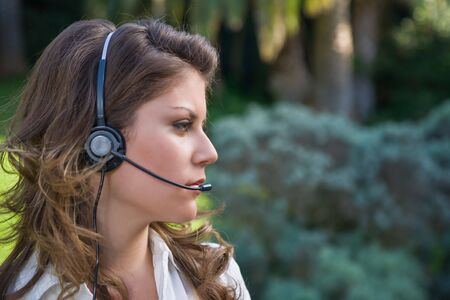 Young and beautiful callcenter operator working outdoor with headset