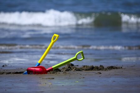 toy on a sandy beach with the ocean in the background on a sunny day.の写真素材