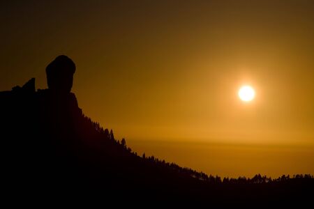 orange sunset with mountain and pine forestの写真素材