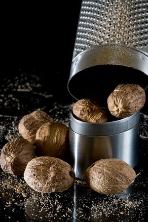 nutmeg and silver grater on black backgroundの写真素材