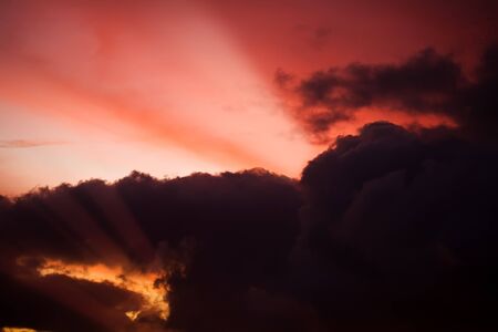 high dramatic sky at sunrise with light ray across the clouds