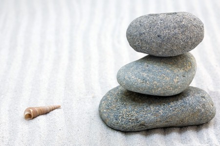zen composition with stack of grey stone over sandの写真素材